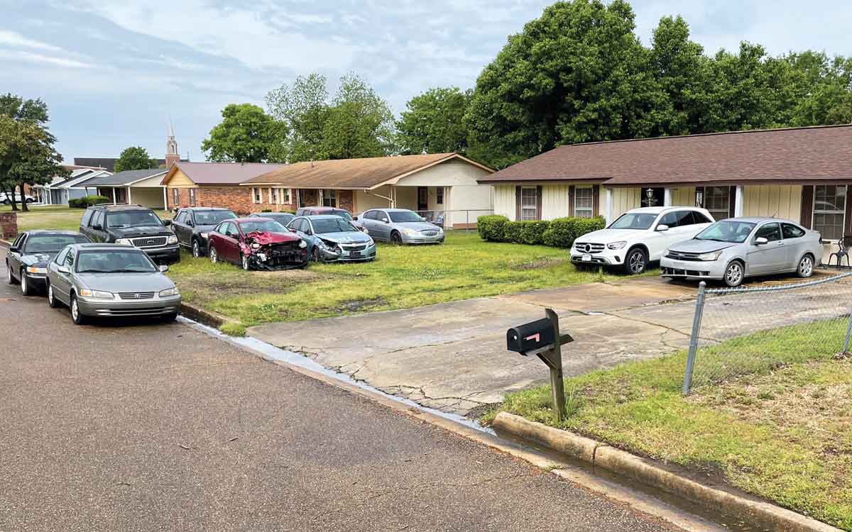 This house on Boyd Street has more than a dozen cars in one yard in a residential neighborhood.