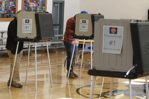 Voters fill out ballots at an elementary school in Tesuque, N.M., on Tuesday, Nov. 8, 2022. A federal judge has ruled, Tuesday, April 2, 2024, that New Mexico election regulators violated public disclosure provisions of the National Voter Registration Act in withholding voter rolls from a conservative group and its public online database. (AP Photo/Morgan Lee, File)