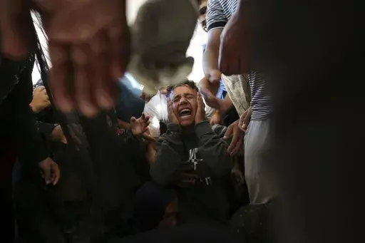 Palestinians mourn their relatives killed in the Israeli bombardment of the Gaza Strip at a hospital morgue in Khan Younis, southern Gaza Strip, Monday, June 24, 2024. (AP Photo/Jehad Alshrafi)