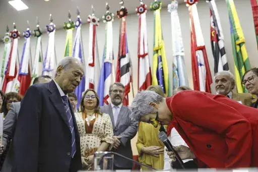 Eneá de Stutz e Almeida, right, president of the Amnesty Commission lowers her head as she apologizes in Brasilia, Brazil Thursday, July 25, 2024. The Brazilian government on Thursday apologized for human rights violations in the persecution and internment of Japanese immigrants in the years after World War II. (Kyodo News via AP)