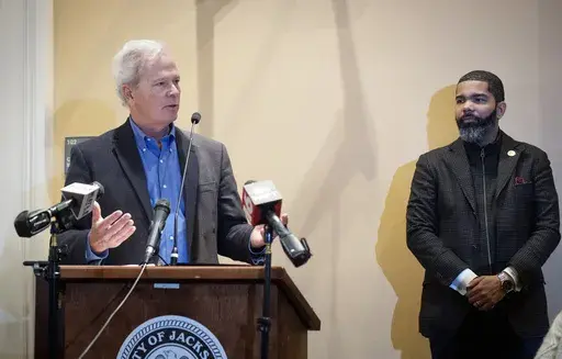 Ted Henifin, left, the City of Jackson water system third-party administrator, addresses media questions during a news conference at City Hall as Jackson Mayor Chokwe Antar Lumumba listens on Dec. 5, 2022, in Jackson, Miss. A District Court Judge said Tuesday, May 9, 2023, that he plans on placing Jackson's sewer system under the authority of Henifin, who was appointed in November to address the city's water troubles. The water system partially failed in August, and for days people had to wait i