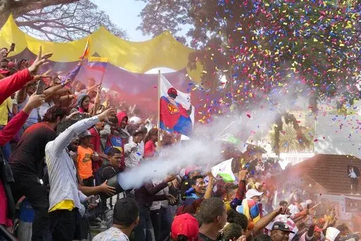A banner of President Nicolás Maduro depicted as a superhero is held amid supporters as they are showered in confetti during an event marking Youth Day at the Miraflores Presidential Palace in Caracas, Venezuela, Sunday, Feb. 12, 2023. A generation of children in Venezuela have only known a country in crisis, plagued over the last decade or more by shortages and inflation. They have also known only one president, Nicolás Maduro. He took over when his mentor Hugo Chávez died of cancer a decade