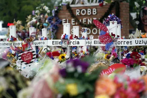Crosses are surrounded by flowers and other items at a memorial, June 9, 2022, for the victims of a shooting at Robb Elementary School in Uvalde, Texas. (AP Photo/Eric Gay, File)
