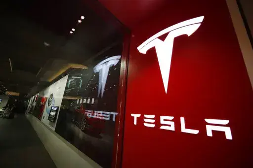 A sign bearing the company logo outside a Tesla store in Cherry Creek Mall in Denver, Feb. 9, 2019. Elon Musk has sold 4.4 million shares of  Tesla stock worth roughly $4 billion, most likely to help fund his purchase of Twitter. (AP Photo/David Zalubowski, File)