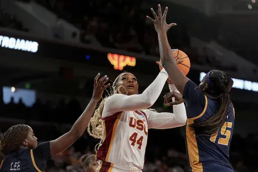 Southern California forward Kiki Iriafen (44) drives to the basket against UNC Greensboro guard Jaila Lee and forward Khalis Cain (15) during the first half in the first round of the NCAA college basketball tournament Saturday, March 22, 2025, in Los Angeles. (AP Photo/Eric Thayer)
