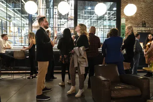 People mingle at a Philadelphia Distilling Daters Mixer Hosted by Date Him Philly, in Philadelphia, Tuesday, Nov. 14, 2023. Some of the most populous urban areas in the United States have an imbalanced sex ratio. Many of the largest counties along the Eastern Seaboard and in the Deep South skew female, while the largest urban counties in the West tilt male, according to data released this fall from the 2022 American Community Survey (AP Photo/Matt Rourke)