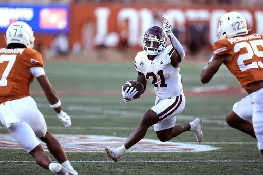 Mississippi State running back Davon Booth (21) runs against Texas defensive backs Jahdae Barron (7) and Jelani McDonald (25) during the second half of an NCAA college football game in Austin, Texas, Saturday, Sept. 28, 2024. (AP Photo/Eric Gay)