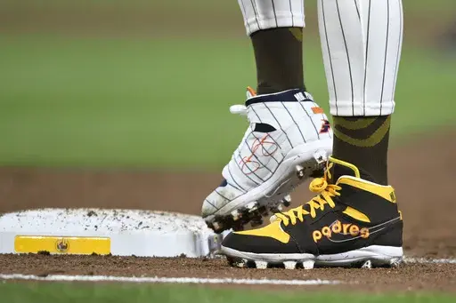 San Diego Padres' Fernando Tatis Jr. (23) wears cleats commemorating the Padres's 1980's and 1990's teams during a baseball game against the Chicago Cubs, Monday, April 8, 2024, in San Diego. Tatis plans to unveil 50 pairs of custom cleats this season in conjunction with his branding company, Xample, and Los Angeles-based Shoe Surgeon. The cleats will honor people, events and whatever strikes the 25-year-old Tatis' fancy. (AP Photo/Denis Poroy, File)