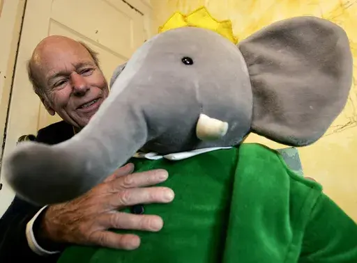 Babar author Laurent de Brunhoff poses for a photograph with Babar while celebrating 75 years of the book on Friday, April 21, 2006 at Mabel's Fables in Toronto, Ontario, Canada. De Brunhoff, a Paris native who moved to the U.S. in the 1980s, died Friday, March 22, 2024 at his home in Key West, Fla., according to The New York Times. (Nathan Denette /The Canadian Press via AP)