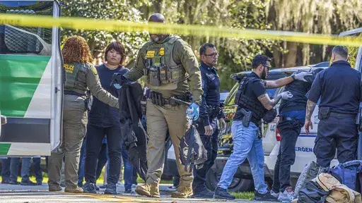 Law enforcement officers detain migrants in the area in Coral Gables, Fla., Jan. 28, 2025. (Pedro Portal/Miami Herald via AP File)
