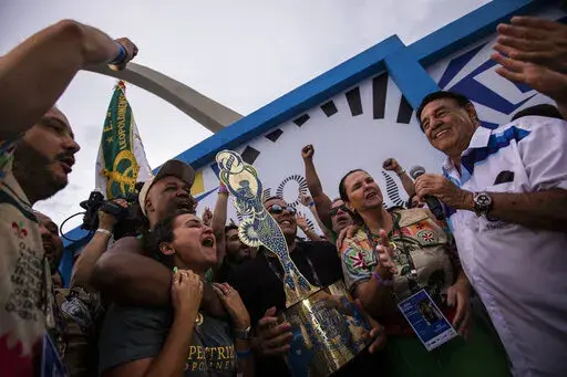Members of Imperatriz Leopoldinense samba school celebrate after receiving the top trophy for the best samba school parade during Carnival celebrations at the Sambadrome in Rio de Janeiro, Brazil, Wednesday, Feb. 22, 2023. (AP Photo/Bruna Prado)