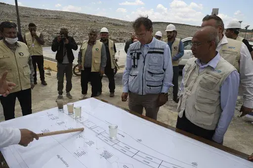 U.N. Deputy Regional Humanitarian Coordinator for the Syria Crisis David Carden, center, inspects a wastewater treatment project in the village of Bhora, in Idlib province, Syria, Tuesday, May 14, 2024. Syria's devastating civil war, now in its 14th year, remains largely frozen and so are efforts to find a viable political solution to end it, while millions of Syrians have been pulled into poverty, and struggle with accessing food and health care as the economy deteriorates across the country's 