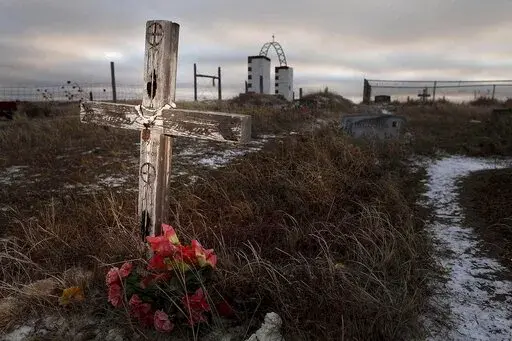 This Feb. 7, 2012 photo shows a cross on a grave at the Wounded Knee National Historic landmark in South Dakota. Two American Indian tribes in South Dakota have agreed to purchase 40 acres of land near the Wounded Knee National Historic Landmark on the Pine Ridge Indian Reservation. (Rapid City Journal via AP)