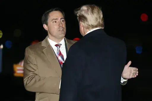 President Donald Trump greets Ohio Secretary of State Frank LaRose, Jan. 9, 2020, as he arrives at Toledo Express Airport, in Swanton, Ohio. The Republican secretaries of state in Ohio, West Virginia and Missouri all have promoted their states’ elections as fair and secure. Yet each also is navigating a fine line on how to address election fraud conspiracies, as they eye campaigns for U.S. Senate or governor in 2024. (AP Photo/ Jacquelyn Martin, File)