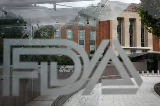 A U.S. Food and Drug Administration building is seen behind FDA logos at a bus stop on the agency's campus in Silver Spring, Md., on Aug. 2, 2018. Federal health advisers voted against an experimental treatment for Lou Gehrig’s disease at a Wednesday, Sept. 27, 2023, meeting prompted by years of patient efforts seeking access to the unproven therapy. (AP Photo/Jacquelyn Martin, File)