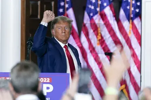 Former President Donald Trump gestures after speaking at Trump National Golf Club in Bedminster, N.J., June 13, 2023, after pleading not guilty in a Miami courtroom earlier in the day to dozens of felony counts that he hoarded classified documents and refused government demands to give them back. An onscreen headline on Fox News Channel called President Biden a “wannabe dictator” who sought to have his political rival arrested. It was shown on Fox Monday night, beneath a split-screen image o