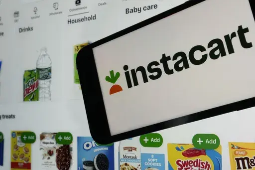 An instacart logo and an instacart webpage are shown in this photo, in New York, Wednesday, Sept. 6, 2023. nstacart is partnering with Uber Eats to offer restaurant delivery to its customers. Instacart said Tuesday that its U.S. shoppers will see a “Restaurants” tab in the company’s app in the coming weeks. (AP Photo/Richard Drew, File)