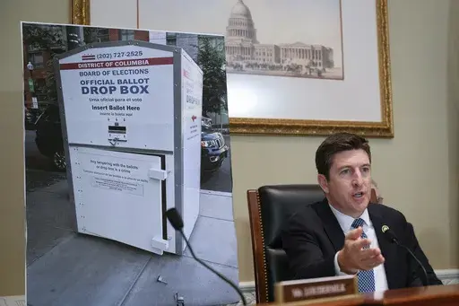 Bryan Steil, R-Wis., chairman of the Committee on House Administration, displays a large photo of an unlocked election ballot drop box in Washington, during a hearing about noncitizen voting in U.S. elections. on Capitol Hill, Thursday, May 16, 2024 in Washington. In recent months, the specter of noncitizens voting in the U.S. has erupted into a leading rallying cry for Republicans. (AP Photo/John McDonnell)