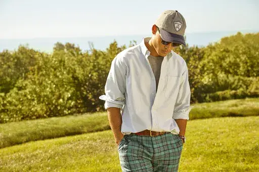 This photo provided by Brooks Brothers shows a model showing a Brooks Brothers casual office wardrobe.  Going back to the office, many don't want to return to structured looks like suits,  zip-front pants and pencil skirts from the pre-pandemic days. But they also don't want to look unprofessional. So they're experimenting with new approaches, forcing retailers and clothing brands to respond with colorful  blazers in knit or sweatshirt fabrics,  pants with drawstrings or elastic bands, and new c