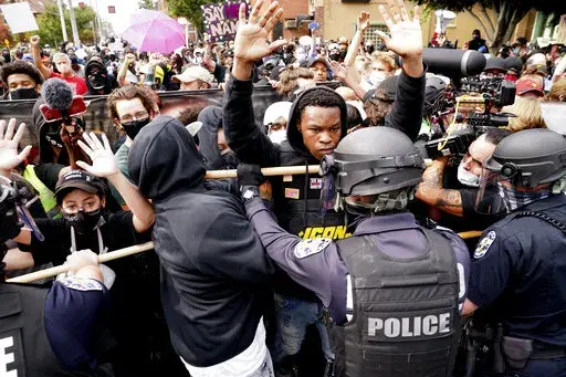 Police and protesters converge during a demonstration, Wednesday, Sept. 23, 2020, in Louisville, Ky.  Recent revelations about the search warrant that led to Breonna Taylor’s death have reopened old wounds in Louisville’s Black community and disrupted the city’s efforts to restore trust in the police department. (AP Photo/John Minchillo, File)