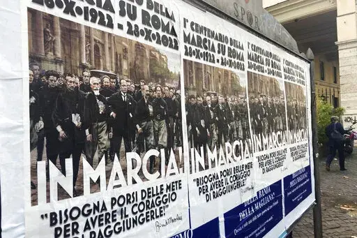Posters commemorating the 100th anniversary of the March on Rome bearing a picture of Italian Fascist Dictator Benito Mussolini reading: "Marching!" with a quote by Mussolini "you have to set yourself goals to have the courage to reach them" are posted on the Rome's public billboard space, Thursday, Oct. 27, 2022. The posters were later ordered removed by Rome's Mayor Roberto Gualtieri. (AP Photo/Gregorio Borgia)