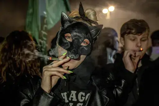 People smoke marijuana cigarette in front of the Brandenburg Gate during the 'Smoke-In' event in Berlin, Germany, Monday, April 1, 2024. Starting 1 April, Germany has legalised cannabis for personal use. As per the new law, Adults aged 18 and over will be allowed to carry up to 25 grams of cannabis for their own consumption. (AP Photo/Ebrahim Noroozi)
