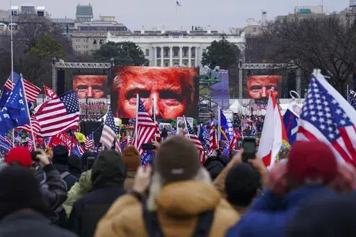 In this Jan. 6, 2021 file photo, Trump supporters participate in a rally in Washington. On Friday, Oct. 21, 2022, The Associated Press reported on stories circulating online incorrectly claiming that former President Donald Trump signed an order to deploy 20,000 National Guard troops before his supporters stormed the U.S. Capitol on Jan. 6, 2021, but was stopped by the House sergeant at arms, at the behest of Speaker Nancy Pelosi.  (AP Photo/John Minchillo, FIle)