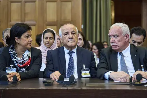 Palestinian foreign policy advisor Riad Malki and other members of the legal team take their seats before judges enter the International Court of Justice, or World Court, in The Hague, Netherlands, Friday July 19, 2024, where the United Nations top court is delivering a nonbinding advisory opinion Friday on the legality of Israel's 57-year occupation of lands sought for a Palestinian state, a ruling that could have more effect on international opinion than it will on Israeli policies. (AP Photo/