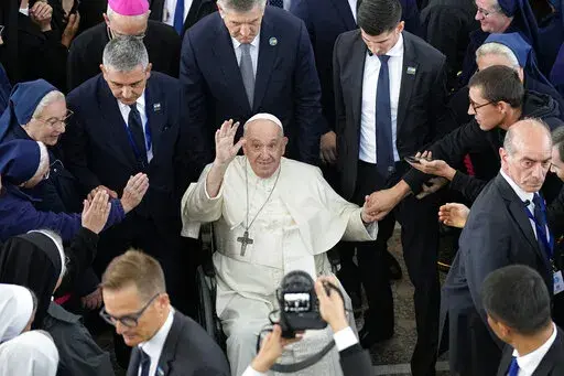 Pope Francis waves at the end of a meeting with priests, religious men and women, seminarians and catechists at the Our Lady Of Perpetual Help Cathedral in Nur-Sultan, Kazakhstan, Thursday, Sept. 15, 2022. Pope Francis is on the third day of his three-day trip to Kazakhstan. (AP Photo/Alexander Zemlianichenko)