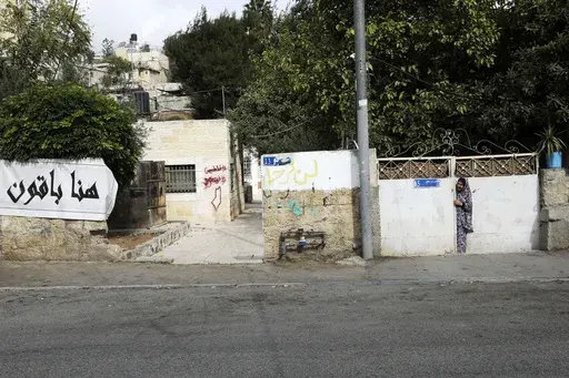 A Palestinian resident of the Sheikh Jarrah neighborhood of east Jerusalem stands near a sidewalk, Nov. 2, 2021. An Israeli court on Monday, April 15, 2024 ordered the eviction of a Palestinian family in the contested neighborhood of east Jerusalem, the latest in a legal saga that has come to symbolize the conflicting claims to the holy city. (AP Photo/Mahmoud Illean, file)