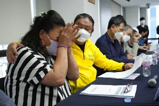 Park Sun-yi, left, a victim of Brothers Home, weeps during a press conference at the Truth and Reconciliation Commission office in Seoul, South Korea, Wednesday, Aug. 24, 2022. The commission has found the country's past military governments responsible for atrocities committed at Brothers Home, a state-funded vagrants' facility where thousands were enslaved and abused from the 1960s to 1980s. (AP Photo/Ahn Young-joon)