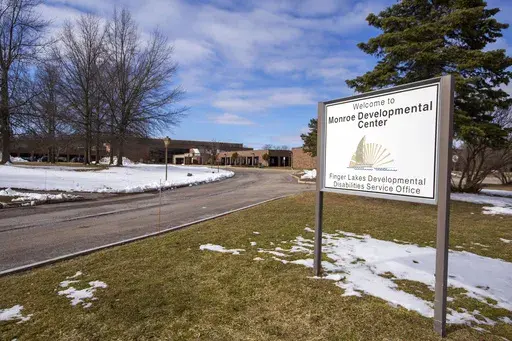 A sign for the Monroe Developmental Center at the Finger Lakes Developmental Disabilities Service Office on Wednesday, March 8, 2023, in Rochester, N.Y. A woman born to a severely disabled resident of the facility in 1986 has filed a lawsuit saying her mother was raped by an employee whose abuse was covered up by those in charge. (AP Photo/Lauren Petracca)