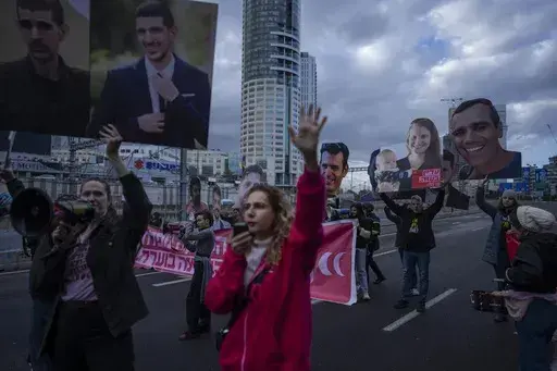 Relatives and supporters of Israelis held hostage in the Gaza Strip, hold photos depicting their faces during a protest demanding their release from Hamas captivity, in Tel Aviv, Israel, Thursday, Feb. 13, 2025. (AP Photo/Oded Balilty)