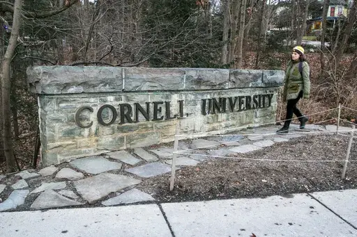 A woman walks by a Cornell University sign on the Ivy League school's campus in Ithaca, New York, on Friday, Jan. 14, 2022. (AP Photo/Ted Shaffrey, File)