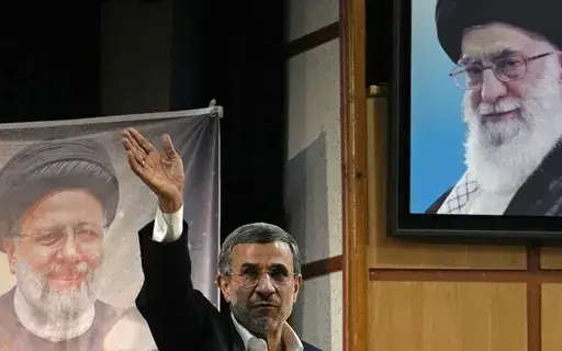 Iran's hard-line former President Mahmoud Ahmadinejad waves to the media as he leaves at the conclusion of a press briefing beside portraits of the Supreme Leader Ayatollah Ali Khamenei, top right, and the late President Ebrahim Raisi after registering his name as a candidate for the June 28 presidential election at the Interior Ministry, in Tehran, Iran, Sunday, June 2, 2024. Ahmadinejad registered Sunday as a possible candidate for the presidential election, seeking to regain the country's top