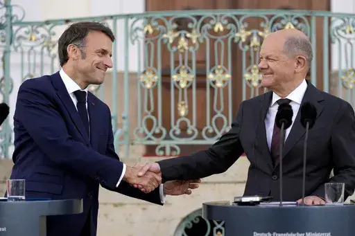 German Chancellor Olaf Scholz, right, and French President Emmanuel Macron shake hands during a press conference at the German government guest house in Meseberg, north of Berlin, Germany, on May 28, 2024. The German government has expressed concern about a possible victory of the far-right National Rally in France. Chancellor Scholz and many ordinary Germans fears that if the the nationalist French party gets elected on Sunday, it would no longer support the close and unique relationship betwee