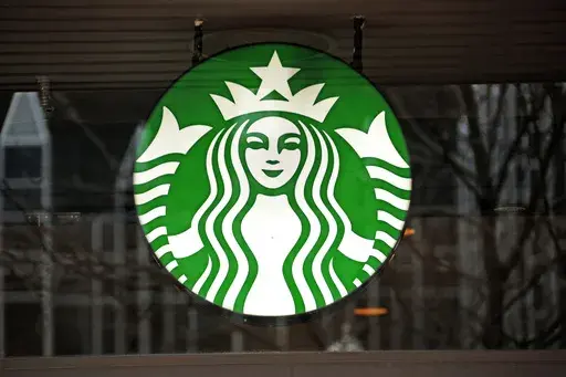 A Starbucks logo sign in the window of one of the chain's cafes in Pittsburgh, Jan. 12, 2017. (AP Photo/Gene J. Puskar, File)