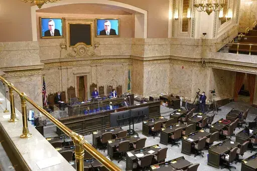House Republican Leader J.T. Wilcox, R-Yelm, is displayed on video screens as he speaks remotely following opening remarks from House Speaker Laurie Jinkins, D-Tacoma, during the opening session of the Washington state House, Jan. 10, 2022, at the Capitol in Olympia, Wash. As lawmakers in some Democratic-led states meet remotely because of renewed COVID-19 concerns, their counterparts in many Republican-led legislatures are beginning their 2022 sessions with an aggressive push to outlaw vaccine 