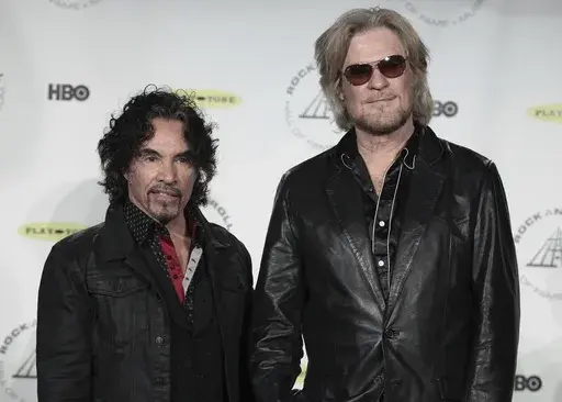 Hall of Fame Inductees John Oates, left, and Daryl Hall appear in the press room at the Rock and Roll Hall of Fame Induction Ceremony on April, 10, 2014, in New York. After more than a half-century of making music together, Hall is suing Oates over a proposed sale of his share of a Hall & Oates business partnership that Hall says he hasn't approved. A Nashville judge recently paused the sale of Oates' stake in Whole Oats Enterprises LLP to Primary Wave IP Investment Management LLC pending arbitr