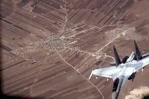 In this image from video released by the U.S. Air Force, a Russian Su-35 flies near a U.S. Air Force MQ-9 Reaper drone on July 5, 2023, over Syria. U.S. officials say that a Russian fighter jet flew very close to a manned U.S. surveillance aircraft over Syria Sunday, July 16, forcing it to go through the turbulent wake and putting the lives of the four-person American crew in danger.(U.S. Air Force via AP)