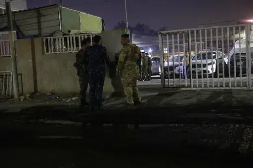 Iraqi security forces gather outside a morgue of Sheikh Zayed Hospital in Baghdad, Monday, Nov. 7, 2022. Assailants shot dead an American aid worker in Baghdad on Monday in a rare killing of a foreigner in the Iraqi capital in recent years, two police officials said. (AP Photo/Hadi Mizban)