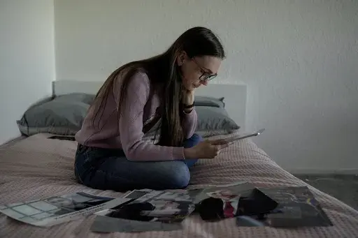 Liusiena Zinovkina, 32, reads a letter from her husband, Kostiantyn, in her room in Berlin, Germany, March 19, 2025. She fled to Germany from Ukraine, where her husband was arrested by invading Russian forces in May 2023. (AP Photo/Ebrahim Noroozi)