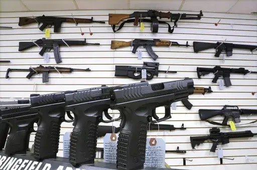 Semi-automatic guns are displayed for sale at Capitol City Arms Supply, Jan. 16, 2013, in Springfield, Ill. Illinois will soon outlaw advertising for firearms that officials determine produces a public safety threat or appeals to children, militants or others who might later use them illegally, as the state continues its quest to curb mass shootings. (AP Photo/Seth Perlman, File)