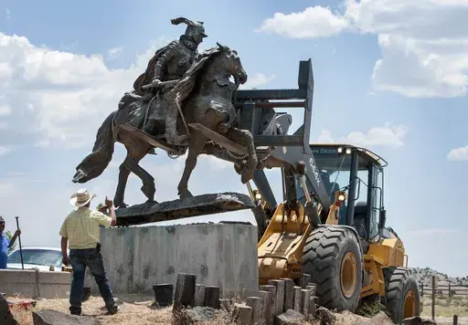 Rio Arriba County workers remove the bronze statue of Spanish conquerer Juan de Onate from its pedestal in front of a cultural center in Alcalde, N.M., June 15, 2020. A settlement has been reached in a civil lawsuit seeking damages from a 23-year-old man and his parents in the shooting of a Native American activist in northern New Mexico amid confrontations about the statue and aborted plans to reinstall it in public. The settlement was disclosed Tuesday, May 7, 2024, in court documents. (Eddie 