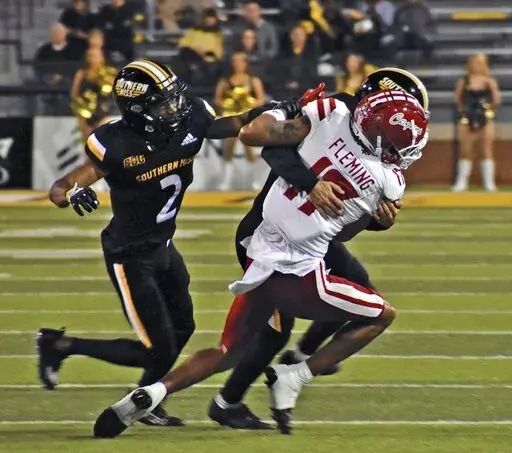 Southern Mississippi defensive back Camron Harrell (29) makes a tackle against Louisiana Lafayette wide receiver Dontae Fleming (17) as Eric Scott Jr. (2) comes into assist during an NCAA college football game, Thursday, Oct. 27, 2022 at M.M. Roberts Stadium in Hattiesburg, Miss. (Hunter Dawkins/The Gazebo Gazette via AP)
