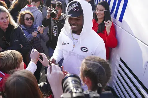 Georgia linebacker Nakobe Dean is greeted by a large crowd of fans as he and his teammates return to the Georgia campus, Tuesday, Jan. 11, 2022, in Athens, Ga., after defeating Alabama in the College Football Championship NCAA college football game. (AP Photo/John Bazemore)