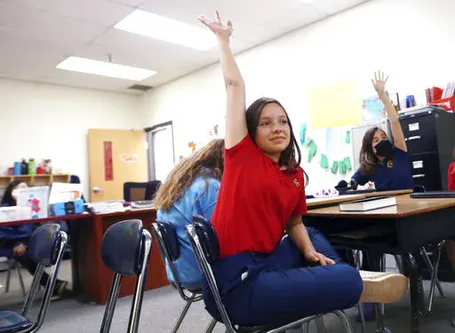 Lilianna Naizer-Baldwin,10, foreground center, raises her hand during her Spanish class at the New Mexico International School in Albuquerque, N.M., on Friday, May 27, 2022. Mary Baldwin a psychology intern at UNM Hospital Health science Center immigrated to the U.S. form Honduras when she was 10. Now her daughter Lilianna is the same age, and thanks to the dual language program she's fluent enough to cook banana-leaf-wrapped tamales with her Spanish-speaking grandmother. New Mexico is the only 
