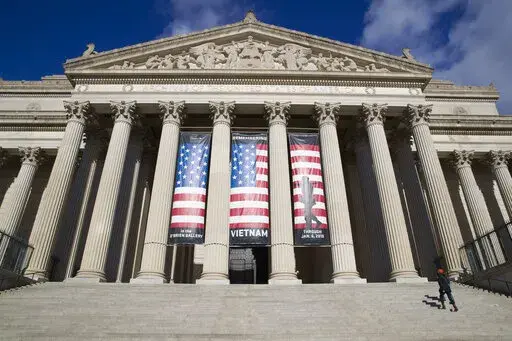 People walk up the steps even though the National Archives is closed with the partial government shutdown, Dec. 22, 2018 in Washington. While the Archives safeguards precious national documents such as the Declaration of Independence, the Constitution and the Bill of Rights, that's only the public face of their sprawling collection, which spans 13 billion pages of text and 10 million maps, charts and drawings, as well as tens of millions of photographs, films and other records. (AP Photo/Alex Br