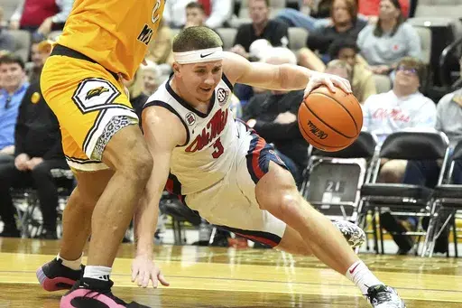 Mississippi guard Sean Pedulla (3) loses his balance as he attempts to dribble past a Southern Mississippi player, left, during the first half of an NCAA college basketball game, Saturday, Dec. 14, 2024, in Biloxi, Miss. (AP Photo/Rogelio V. Solis)