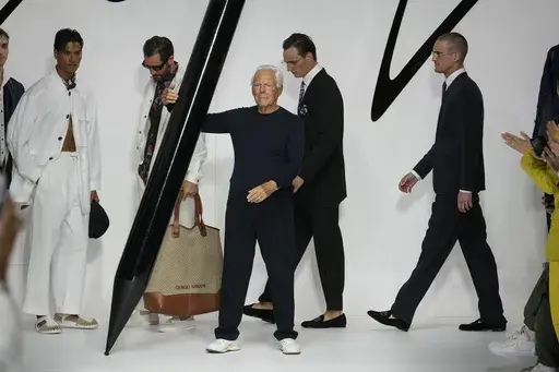 Designer Giorgio Armani receives applause at the end of the Giorgio Armani men's Spring Summer 2024 fashion show presented in Milan, Italy, Monday, June 19, 2023. (AP Photo/Luca Bruno)